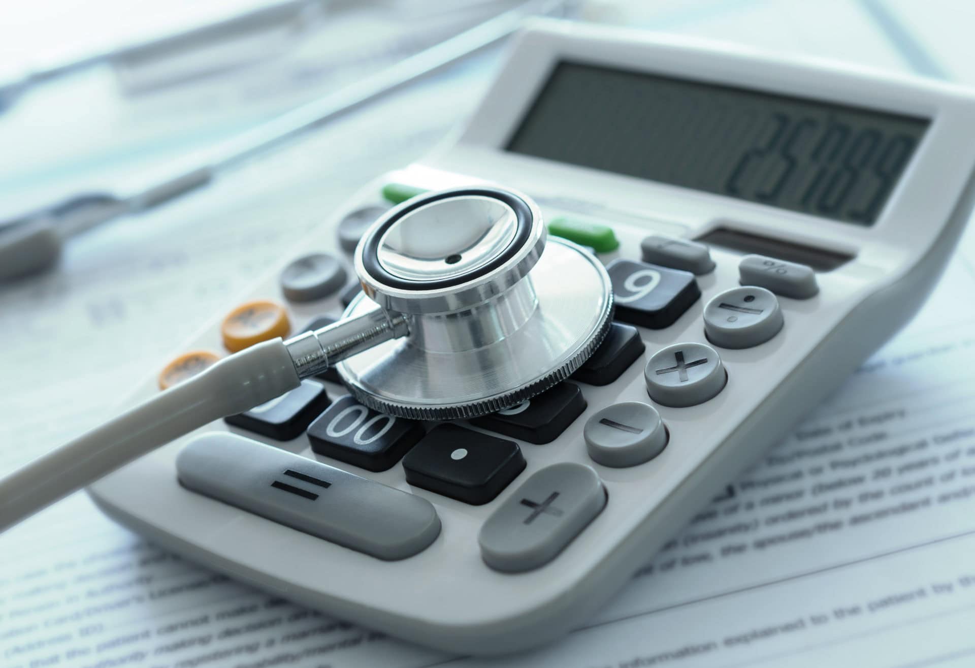 medical finance insurance health care costs or medical insurance savings concept. stethoscope on calculator with medical billing.
